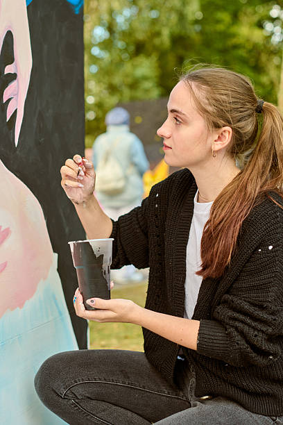 istock Young woman painting outdoors in natural light setting 2231666766