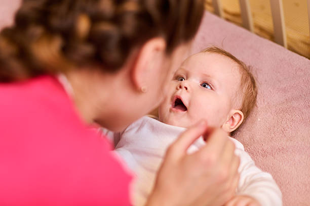 istock Mother engaging with cheerful baby in crib setting 2231666788
