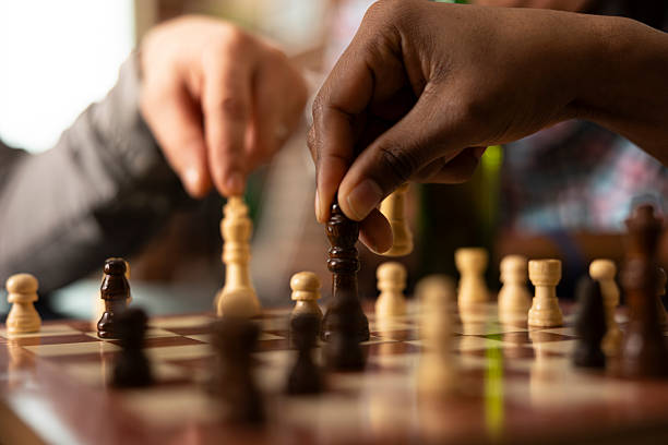 istock Diverse individuals moving chess pieces on board 2231667711