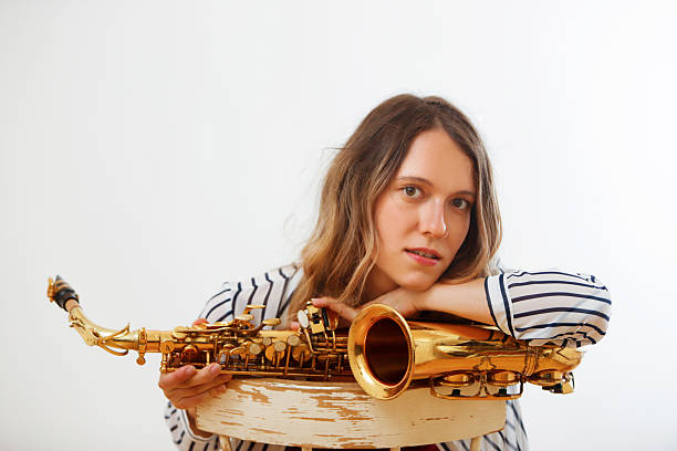 caucasian woman looking into camera with a saxophone
