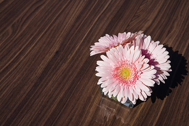 Gerbera flowers as centerpiece on wooden table, decoration for parties, outdoor