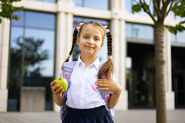 istock Schoolgirl with Backpack and Apple 2231669775