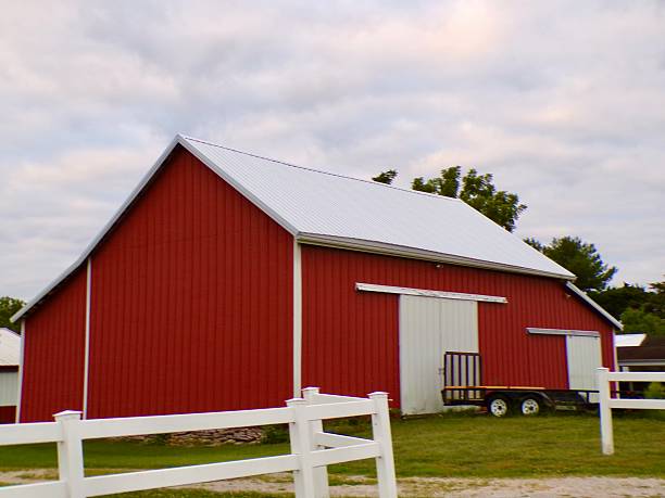 istock Red barn with white fence and white clouds. 2231672257