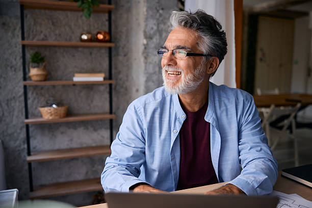 istock Smiling Senior Architect Working From Home Office Looking Out Window 2231674737