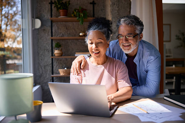 istock Happy senior couple using laptop at home looking at blueprints 2231674851