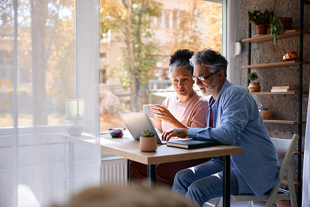 istock Mature couple using laptop and drinking coffee at home 2231674912