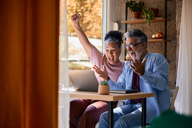 istock Excited senior couple cheering while using laptop at home 2231674977
