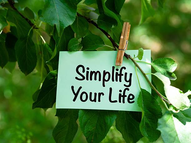 istock Green paper note with words Simplify Your Life hanging on a tree branch 2231676039