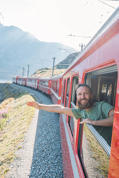 istock Man Enjoying Scenic Train Ride by Lake 2231676408
