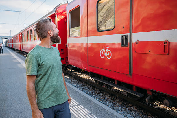 istock Man Walking by Red Train at Station 2231676496