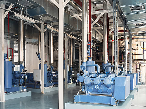 istock An industrial interior featuring large blue machinery and complex piping systems. 2231681597