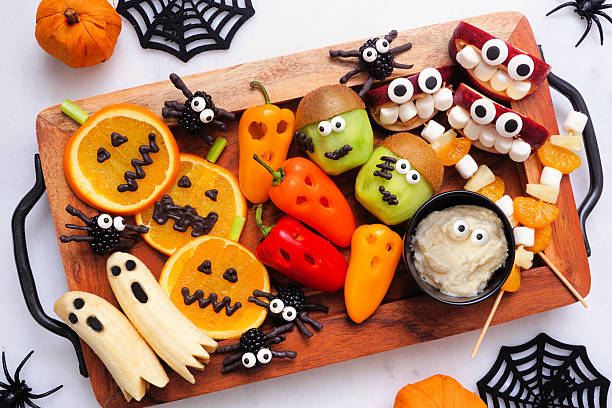 istock Healthy Halloween fruit and vegetable platter. Top view table scene over a white marble background. 2231682154