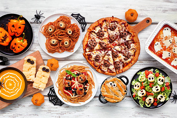 istock Spooky Halloween dinner party table scene over a white wood background 2231683640