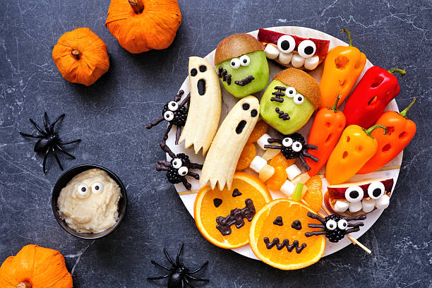 istock Healthy Halloween fruit and vegetable platter. Top down view table scene over a white marble background. 2231683683