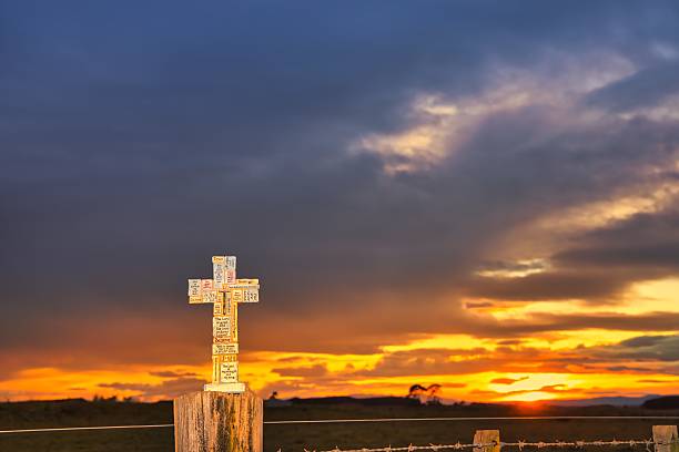 istock Stone Block Cross on Fence Post Sunrise 2231684763