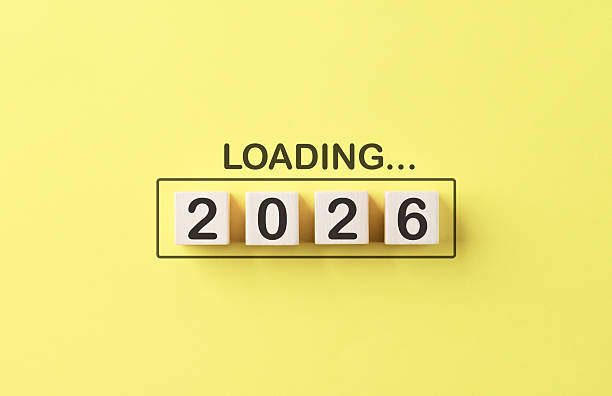 Loading 2026 New Year Progress Concept. Wooden cubes number 2026 inside progress bar with word loading on bright yellow background, symbolizing preparation, progress, goal setting, and upcoming goals.