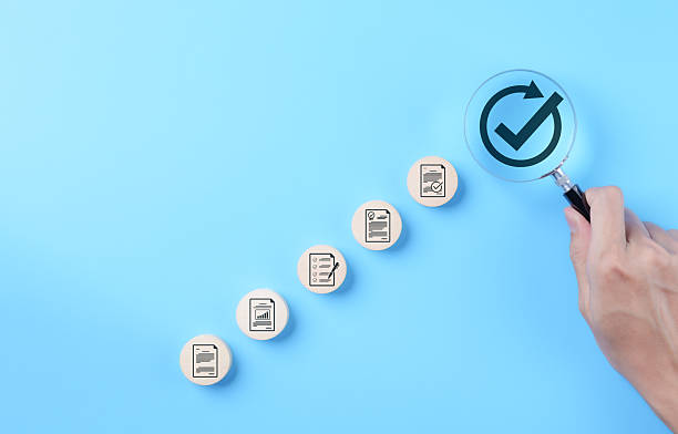 istock Document approval and quality assurance process concepts. Hand holding a magnifying glass focusing on check mark symbol with document icon, document approval, compliance, and quality assurance process 2231685024