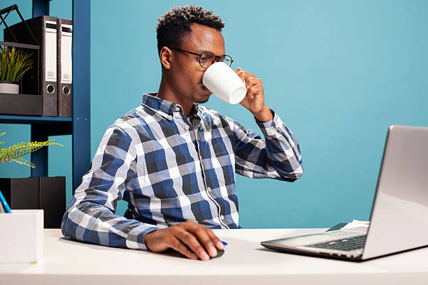 istock Young man drinking coffee at desk 2231687077