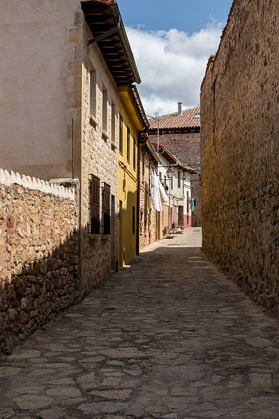 istock Quiet cobblestone street lined with historic buildings under a clear sky 2231687878
