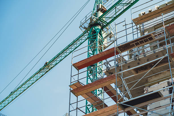 istock Construction site with crane and scaffolding under clear blue sky in urban area 2231695977