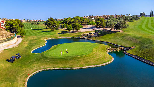 istock Golfers playing on island green surrounded by water 2231696329