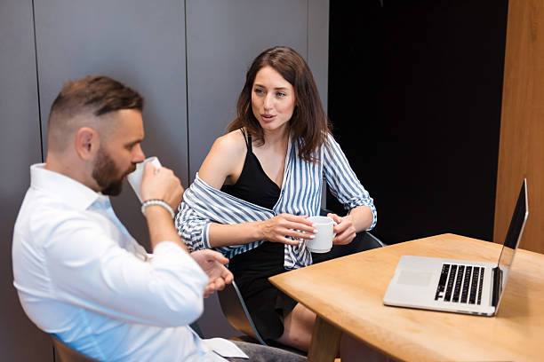 istock Man and woman drinking coffee and discussing working issues 2231696336