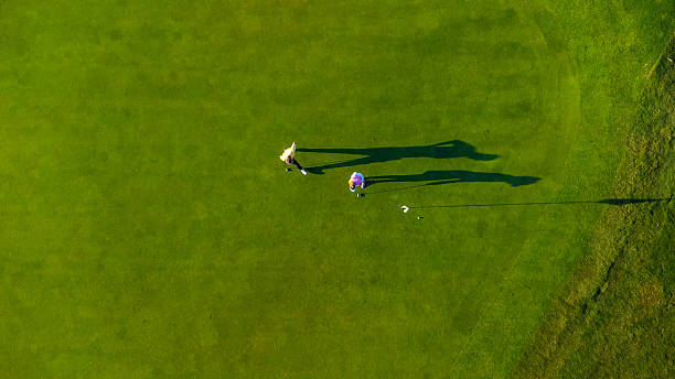 istock Two golfers putting on green grass from above 2231696340