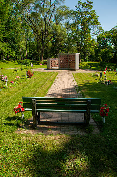 istock Serene Cemetery Memorial Space with Bench and Blossoms on a Sunny Day 2231697194