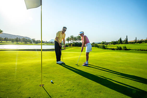 istock Couple enjoying a relaxing day golfing on a sunny course 2231697212