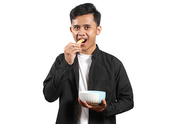 istock Asian man carrying a bowl eating crackers isolated on white background 2231705466