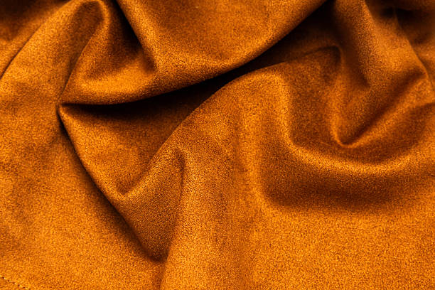 Soft golden fabric texture draping elegantly in warm light creates a luxurious ambiance