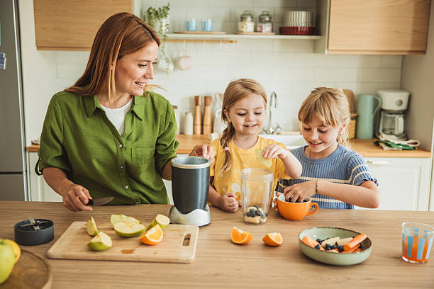 istock Mother and daughters preparing healthy smoothie 2231709107