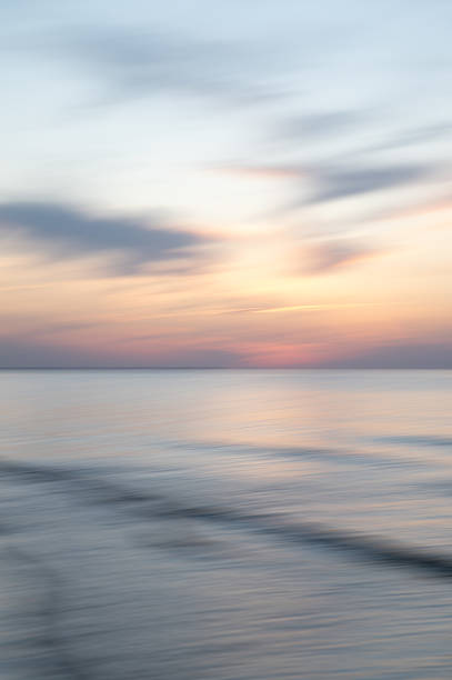 istock A dreamy, impressionistic paint like blurred sea sunset background with gently soft pastel colours. Vertical photo. 2231715239