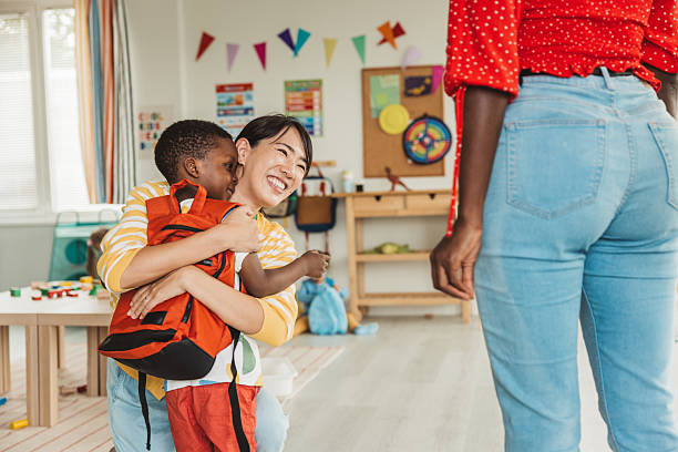 istock Preschool teacher in classroom greeting new student 2231715677