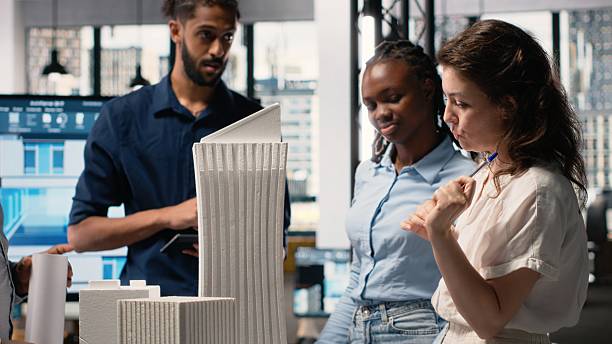 istock Contractors and engineers reviewing 3D models and construction blueprint 2231720368