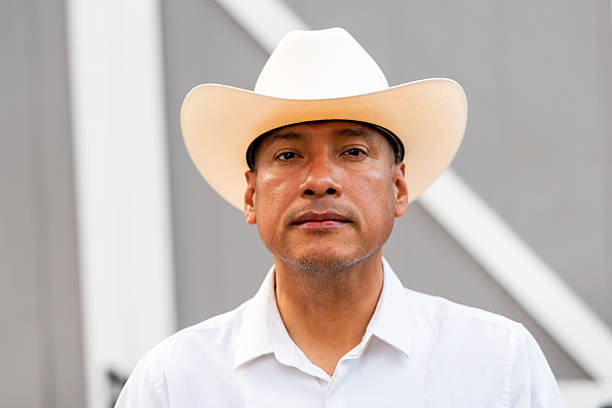 istock Hispanic man posing wearing a cowboy hat looking at camera 2231724919