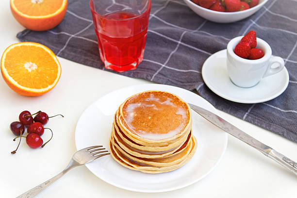 Simple pancake breakfast with jam and apple, tea served on a kitchen table. Simple life concept High quality photo