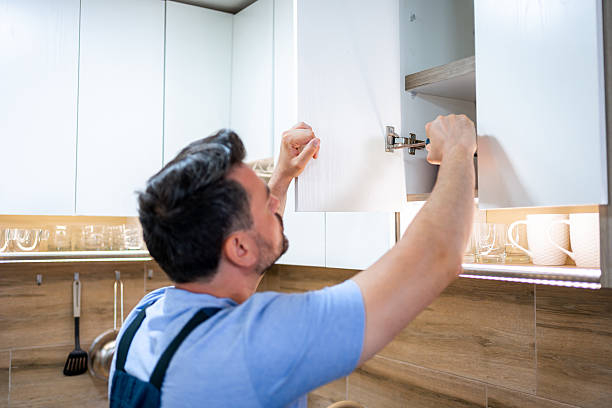 istock Man repairs kitchen cabinet in modern home during daytime activity 2231729721