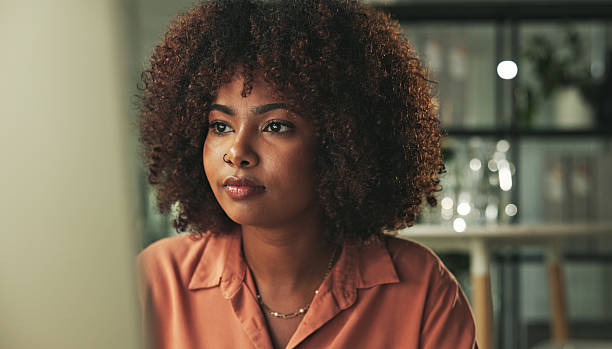 istock Thoughtful Woman Sitting at Desk in a Modern Environment 2231732842