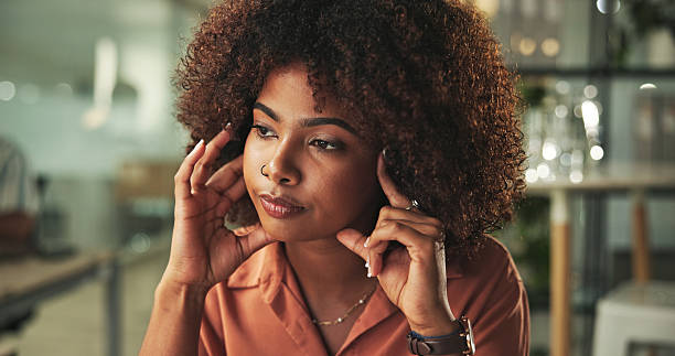 Thoughtful Woman Sitting at Workspace in Modern Office Environment
