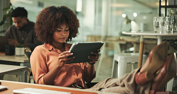 istock Professional Woman Relaxing at Desk While Browsing a Tablet in Modern Office 2231732862