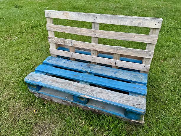 istock Wooden pallet bench on green grass 2231733385
