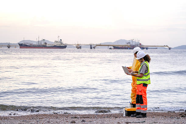 istock Two field scientists in PPE gear analyzing seawater samples using test tubes and a laptop. Environmental monitoring and pollution control on the coastline are depicted. 2231734052