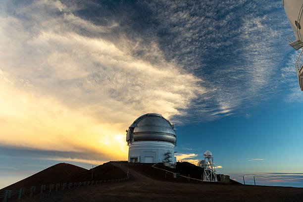 The observatory dome at Mauna Kea, Big Island, Hawaii, stands beneath dramatic evening clouds at the summit.