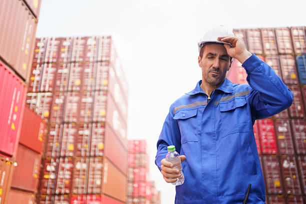 istock Container yard worker is taking a break and drinking water during a very hot day. 2231739731