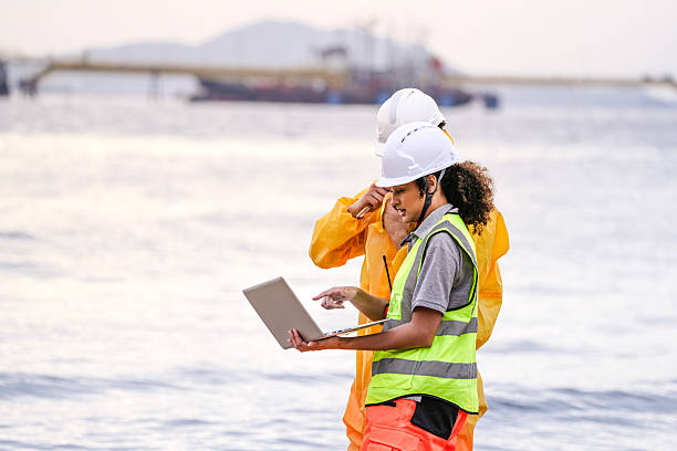 istock Two field scientists in PPE gear analyzing seawater samples using test tubes and a laptop. Environmental monitoring and pollution control on the coastline are depicted. 2231741501