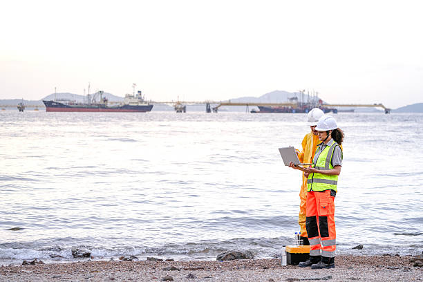 istock Two field scientists in PPE gear analyzing seawater samples using test tubes and a laptop. Environmental monitoring and pollution control on the coastline are depicted. 2231741623