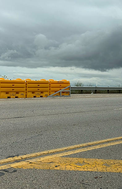 istock Yellow safety barriers on overcast highway road with cloudy sky 2231741718