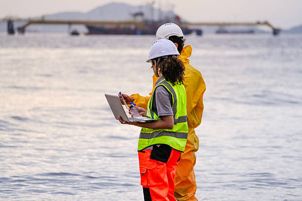 istock Two field scientists in PPE gear analyzing seawater samples using test tubes and a laptop. Environmental monitoring and pollution control on the coastline are depicted. 2231742148