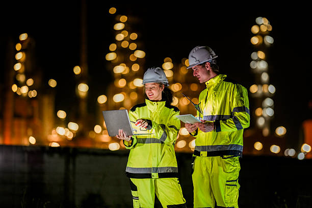 istock Two diverse engineers coordinate operations on a night shift. The man uses a radio while the woman explains data from a digital tablet, a concept for industrial communication. 2231743766